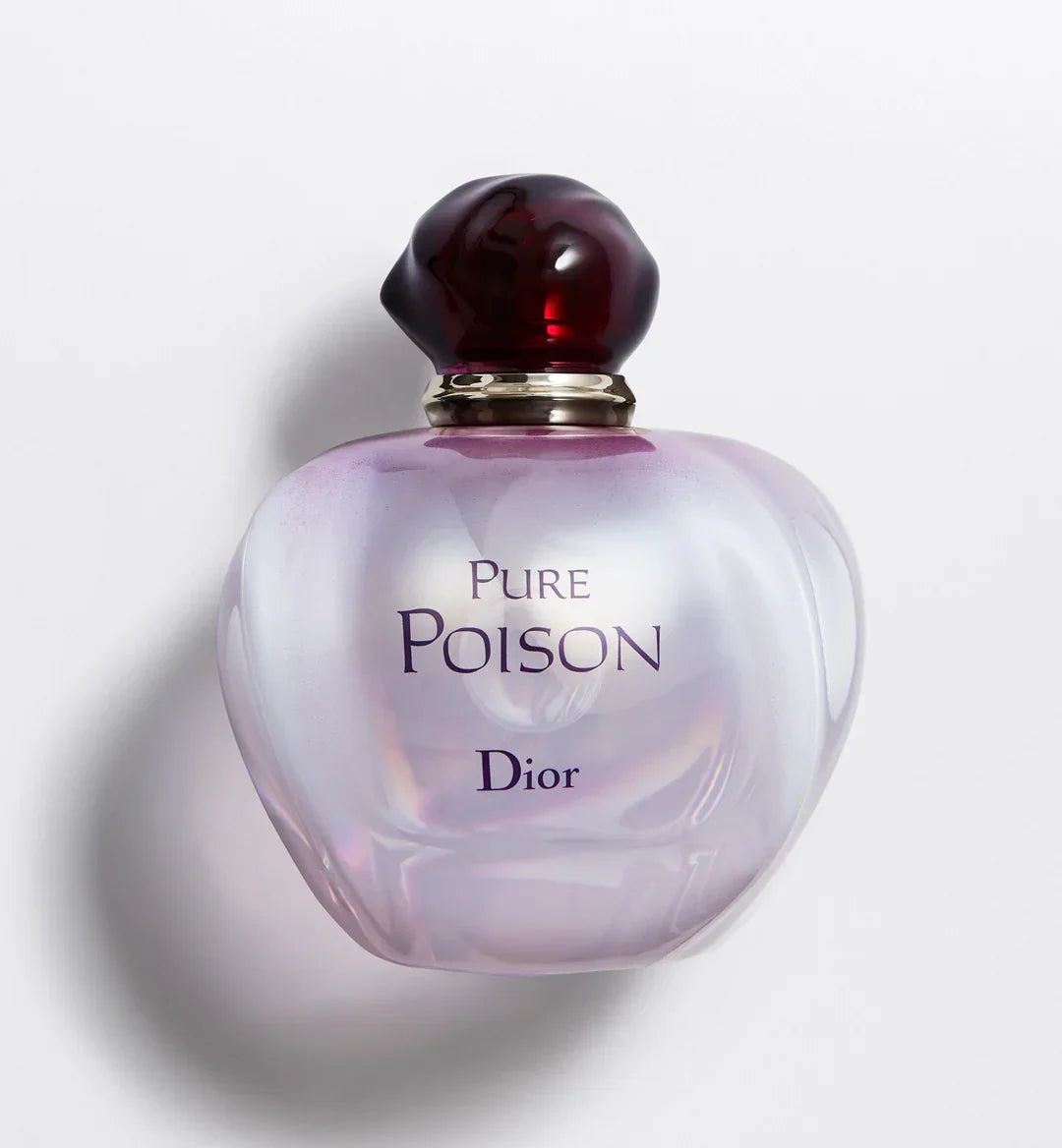 A bottle of Christian Dior's Pure Poison Eau de Parfum with a purple hue and a heart-shaped design, featuring a dark cap.