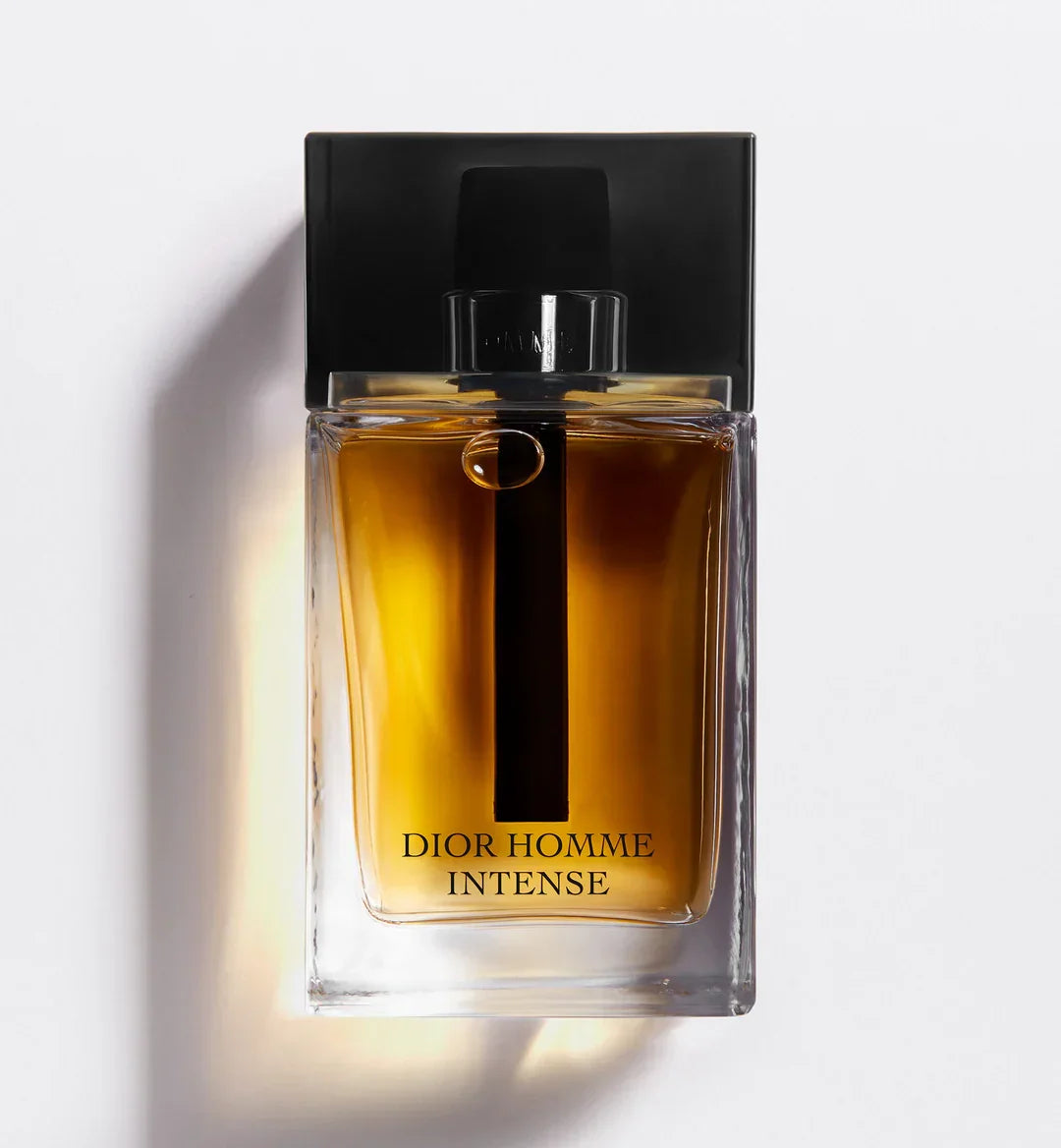 Dior Homme Intense men's perfume bottle with amber liquid, black cap, and sleek glass design