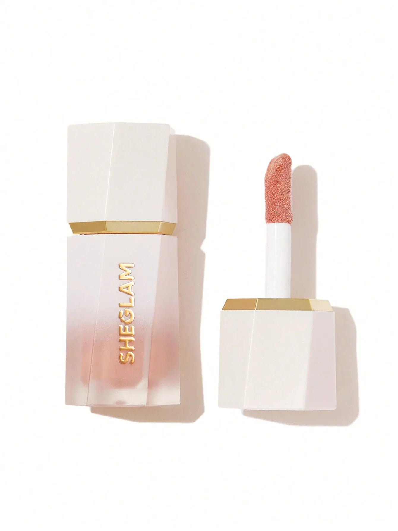 Sheglam shimmer lip gloss in peachy nude, sleek white and gold packaging, beauty makeup product